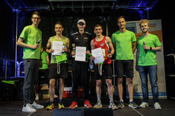 Sieger 10-Kilometer-Lauf Auf der Bühne stehen die ersten drei Plätze der Kategorie männlich, die zwei Moderatoren und der Leiter des Hochschulsports