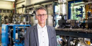 A photo of a man with glasses in a suit.