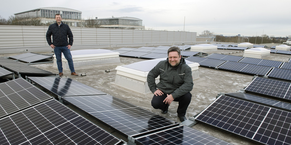 Zwei Männer auf einem Dach mit Photovoltaik-Anlage