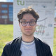 Portrait vom Studenten Rafael Reis vor einem Schild der TU Dortmund