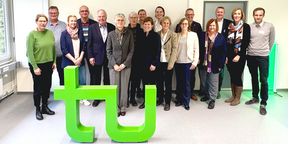 Gruppenfoto des CET vor dem grünen TU Logo