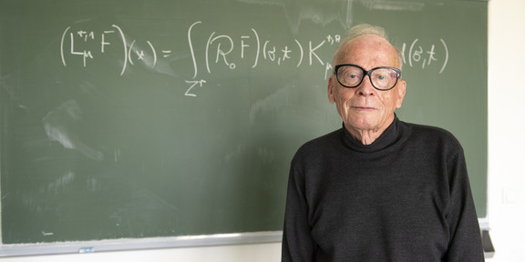 Portrait of Manfred Reimer in front of a chalkboard