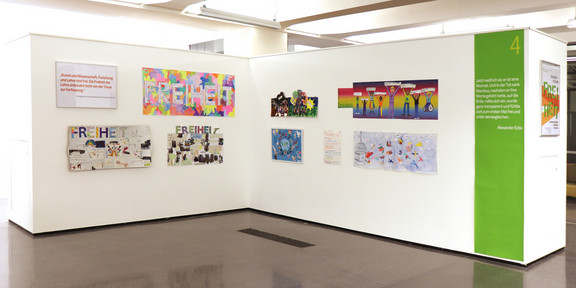 Das Bild zeigt einen Ausstellungsraum mit Bildern.