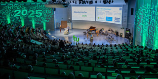 Ein Foto vom vollbesetzten Audimax bei der Akademischen Jahresfeier der TU Dortmund. Am Redepult steht Rektor Prof. Manfred Bayer.