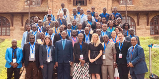 Große Gruppe von Konferenzteilnehmenden posiert vor einem Gebäude der Uganda Christian University.