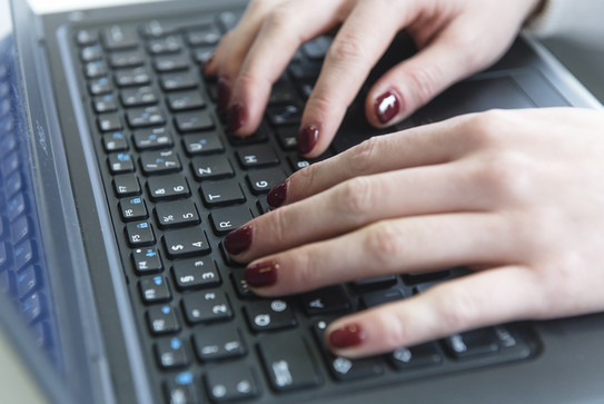 Arbeiten am Laptop Auf dem Foto sieht man zwei Hände, welche aktuell etwas auf einer Laptoptastatur eingeben.