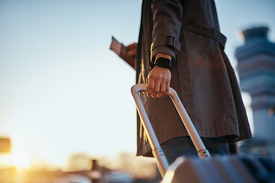 Foto: Eine Person zieht einen Reisekoffer.