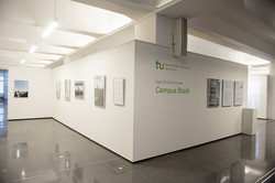 UmBAUkultur Ein Ausstellungsraum mit Fotografien. An einer Wand steht: "Die TU Dortmund begrüßt Sie auf ihrem Campus Stadt.“