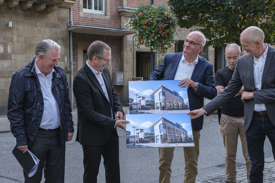 Foto: Fünf Männer, darunter Prof. Manfred Bayer, halten ein Bild in der Hand und lachen sich an.