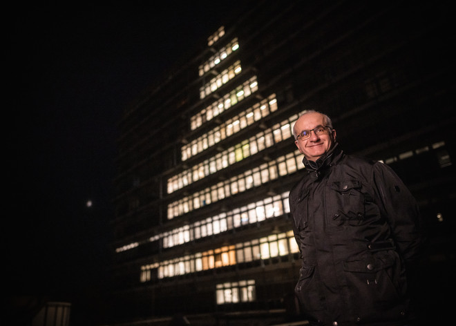 President Manfred Bayer in front of the Math Tower, whose windows are illuminated in a christmas tree shape.