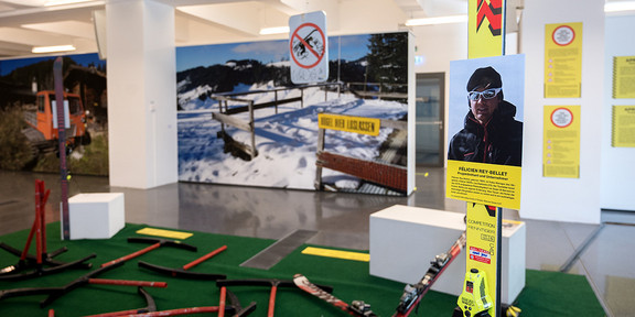 Ausstellung über den Wintersport in den Bergen, mit Bildern von verschneiten Landschaften und Skiausrüstung im Vordergrund.