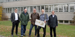 Gruppenfoto_Alumuni-Tag Fünf Männer stehen auf einer Wiese und schauen in die Kamera.