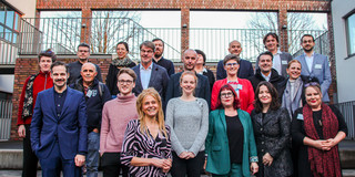 Ein Gruppenfoto im Freien vor einem Gebäude