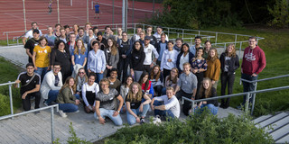 Group picture in front of an outdoor sports facility.