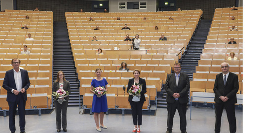 Mehrere Personen stehen in einem Hörsaal