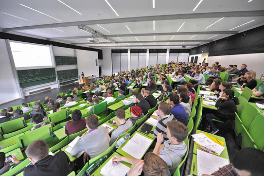 Studierende bei einer Vorlesung im grün bestuhlten Hörsaal Studierende bei einer Vorlesung im grün bestuhlten Hörsaal