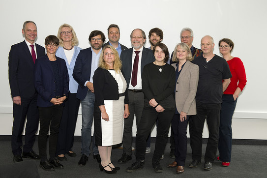 Gruppenfoto: Viele Professorinnen und Professoren vor einer weißen Wand.