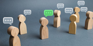 small wooden figures with speech bubbles above their heads