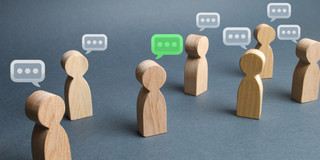 Diskussion kleine Holzfiguren mit Sprechblasen über ihren Köpfen