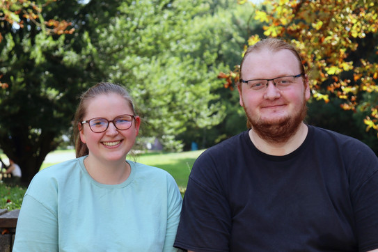 Foto: Annika Ricke und Darius Weitekamp stehen auf dem Campus der TU Dortmund. Im Hintergrund sieht man Bäume.