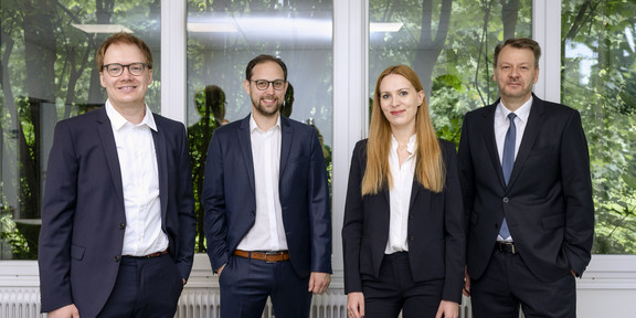 Forschungsteam der TU Dortmund Drei Männer im Anzug und eine Frau im Hosenanzug stehen in einer Reihe nebeneinander.