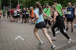 Mehrere Sportler*innen starten ihren Lauf, im Hintergrund steht Publikum