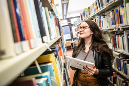 Frau vor einem Regal in der Bibliothek