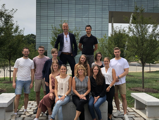 Gruppenfoto vor einem Gebäude mit moderner Glasfassade