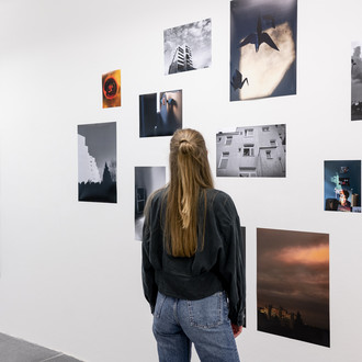 Eine Frau betrachtet Ausstellungsobjekte an einer Wand