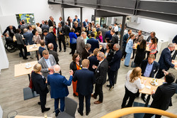 A crowded room with people in suits at a celebration.