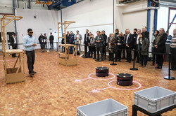 People look at experiments in which containers move independently through a hall