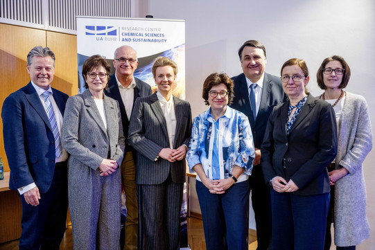 Auf dem Foto sieht man insgesamt acht Personen, die im Rahmen der Eröffnungsfeier für ein Gruppenbild posieren.