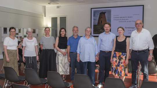 Foto: Mehrere Personen stehen für ein Gruppenfoto in einem Ausstellungsraum.