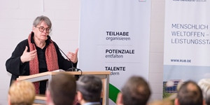 Prof. Barbara Welzel spricht an einem Rednerpult vor Publikum.