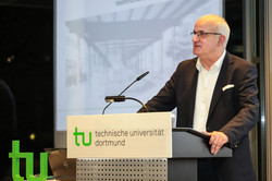 Prof. Manfred Bayer, der an einer Kanzel mit TU-Logo eine Rede hält