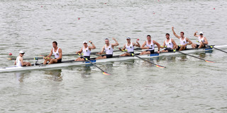 A rowboat with eight rowers on the water.