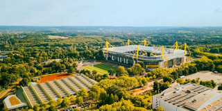 Photo: Aerial view of Signal Iduna Park and its surroundings on a sunny day.