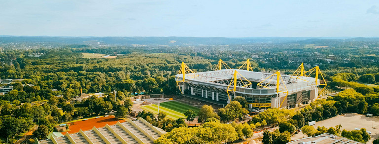 Photo: Aerial view of Signal Iduna Park and its surroundings on a sunny day.