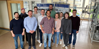 A group photo of people in front of posters