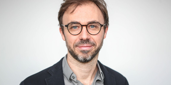 Portrait of Dortmund phyiscist Prof. Dr. Mirko Cinchetti: a middle-aged man with brown hair, beard and glasses smiles slightly into the camera