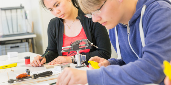 SchnupperUni 2015 eine Schülerin und ein Schüler hantieren mit Bauteilen