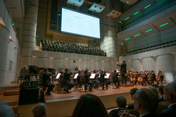 Blick auf Chor und Orchester, die auf der Bühne spielen