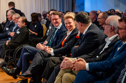 Foto: Wissenschaftsministerin Ina Brandes und Ministerpräsident Hendrik Wüst lachen im Publikum bei der Eröffnung des Research Centers One Health Ruhr.