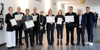 Eine gruppe von Menschen, von denen einige Zertifikate oder Urkunden in der Hand halten