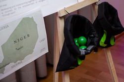 Two bags hang from a standing wall. They are filled with green balls