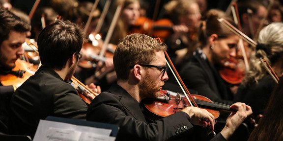 Studentenorchester der TU Dortmund Ein Musiker mit Geige des Studentenorchesters der TU Dortmund im Fokus