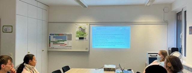 Vier TU-Guides schauen auf die Leinwand und verfolgen die Präsentation.