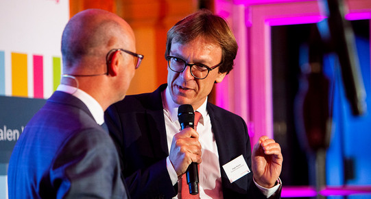 Prof. Holger Wormer mit Mikrofon. Er redet mit einem weiteren Mann.