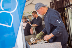 Sommerfest 2022 Ein Mann grillt Bratwürstchen.