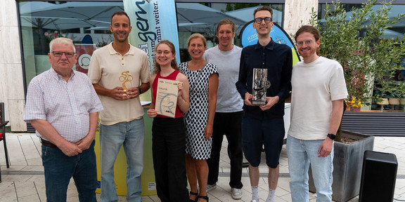 Group of people outdoors at an award ceremony.